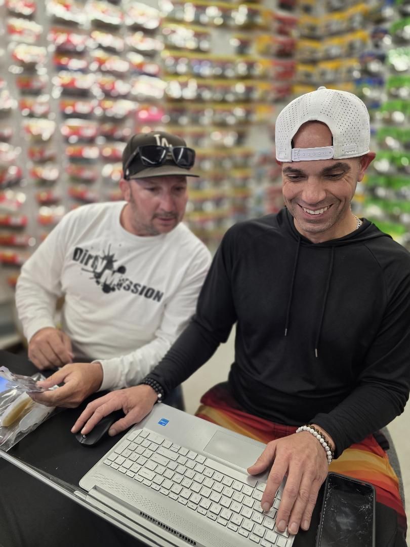 Two men at a laptop taking entries at the registration desk