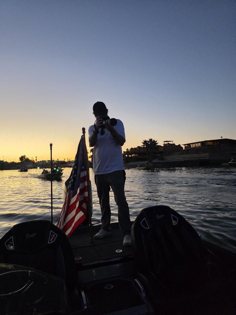 A photographer on a boat shooting the takeoff at sunrise