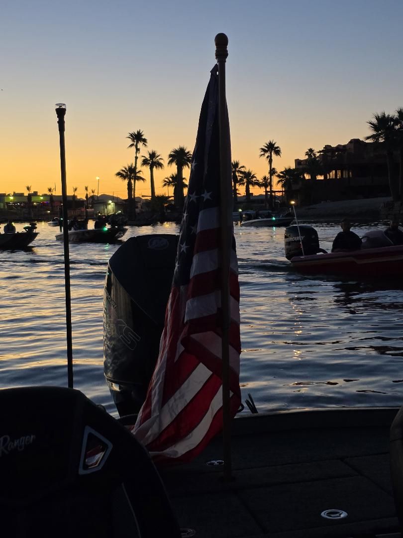 An American flag on the back of a boat at sunrise