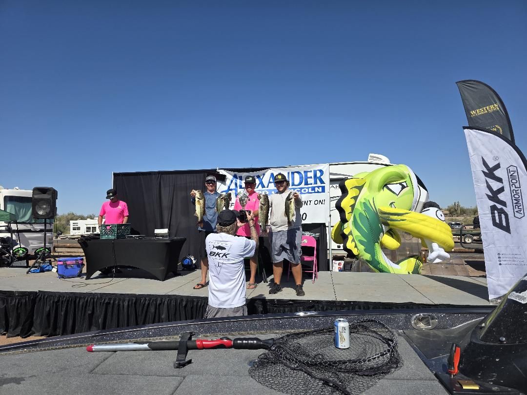 Winners holding their catch on stage seen from the water