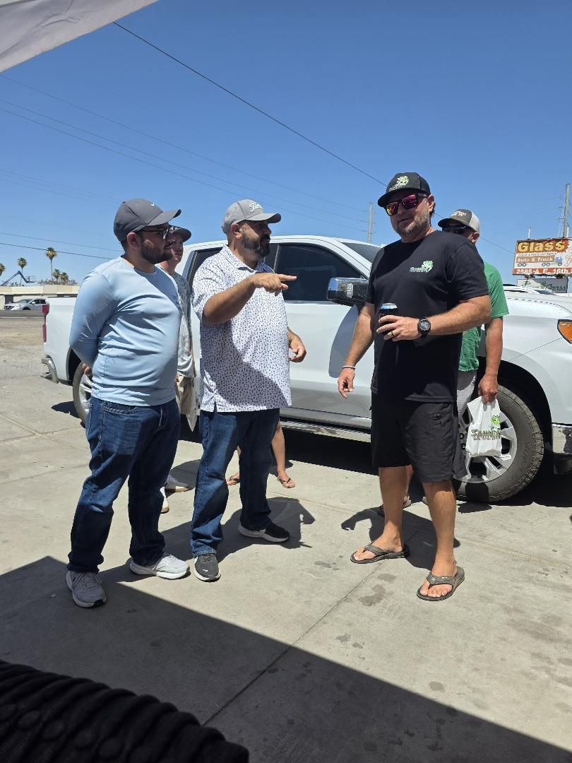 Billy in a black Skinner shirt talking with two anglers by a truck