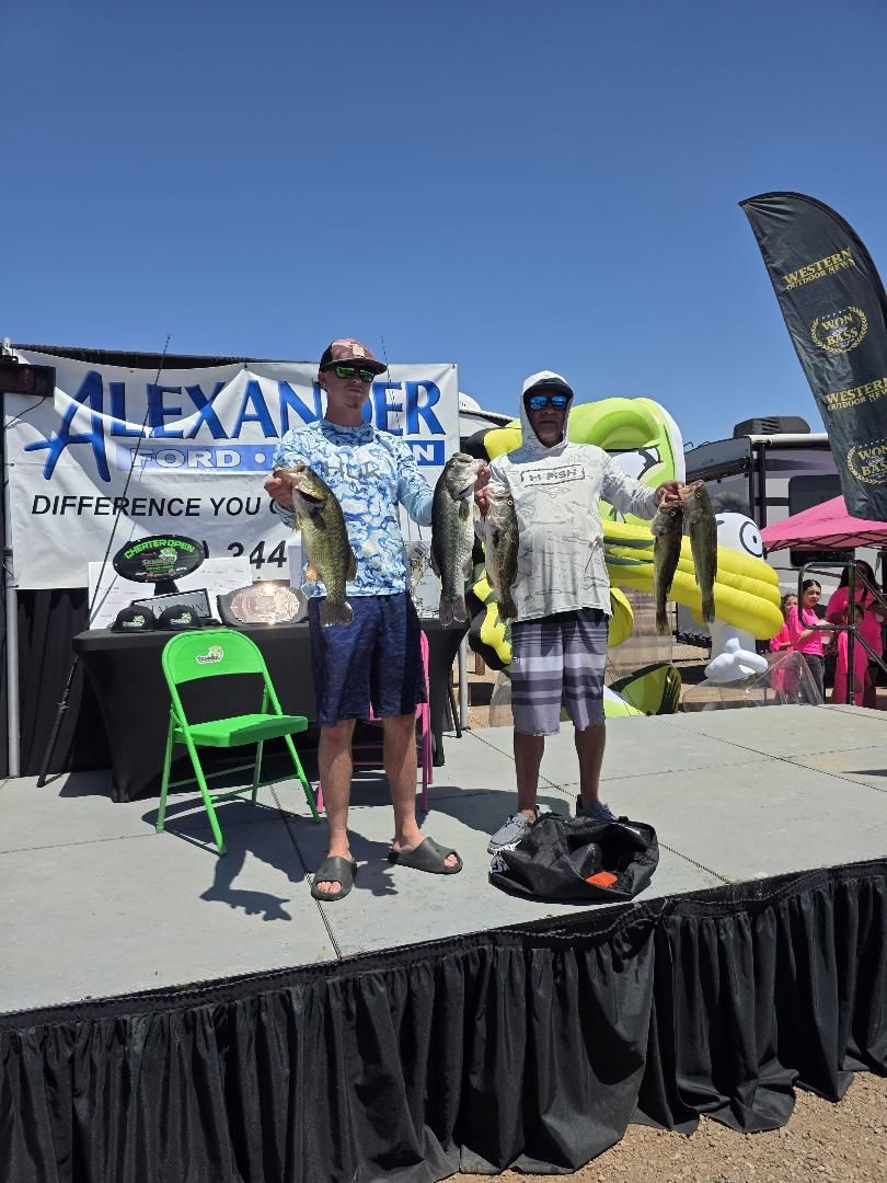 Two anglers on stage holding up their catch