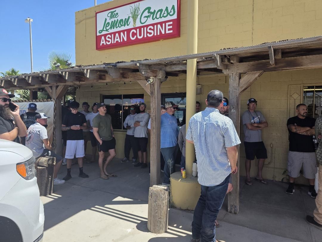 A crowd lined up along a patio outside a restaurant