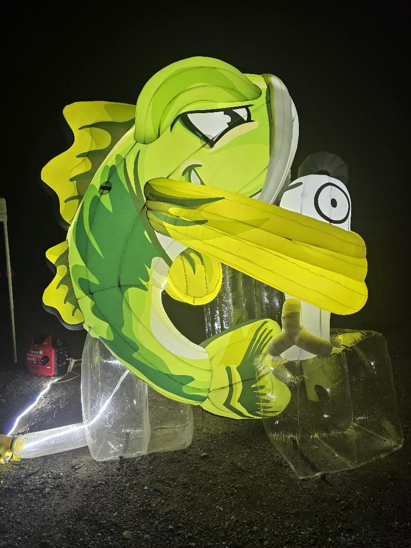 The illuminated inflatable Bruce the Bass sculpture at night